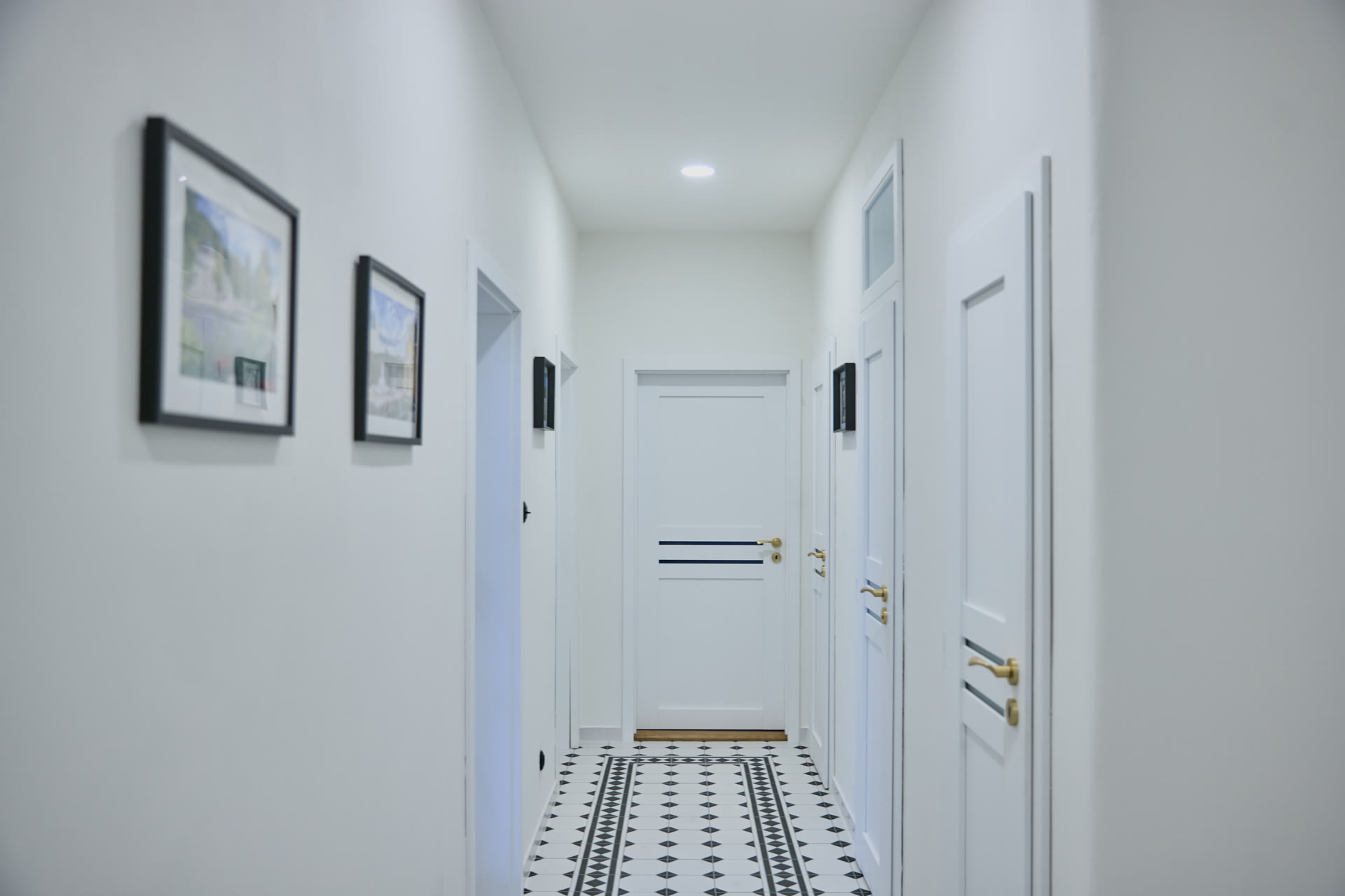 Světlá chodba apartmánu s původní dlažbou